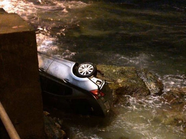 Motorista perde controle de carro e cai nas pedras da Praia das Flechas, em Niterói (Reprodução/ TV Globo)