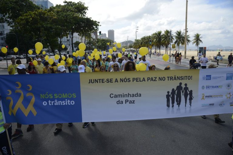 Manifestantes caminham na Praia de Copacabana pedindo por paz no trânsito