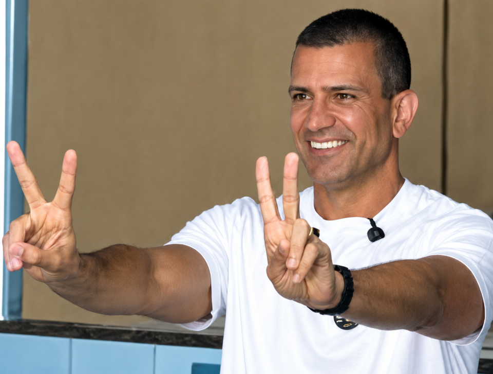 Homem sorridente fazendo sinais de paz